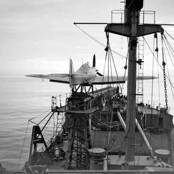 Hawker Sea Hurricane Mark I, V6733, of the Merchant Ship Fighter Unit, on the fo'c'sle catapult on board Catapult Armed Merchantman (CAM ship) SS EMPIRE DARWIN, in a convoy heading for North Africa. Note the flaps pre-selected in the take-off position. The catapult was angled to starboard over the ship's bows to prevent the blast from its rockets hitting the superstructure, and to reduce the risk of the pilot being run over by the ship, should the aircraft ditch after launch.
