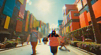 Two people ride bikes on a trail in front of a replica of Versaille Palace. To their left are cute deer and a large decorative fountain.