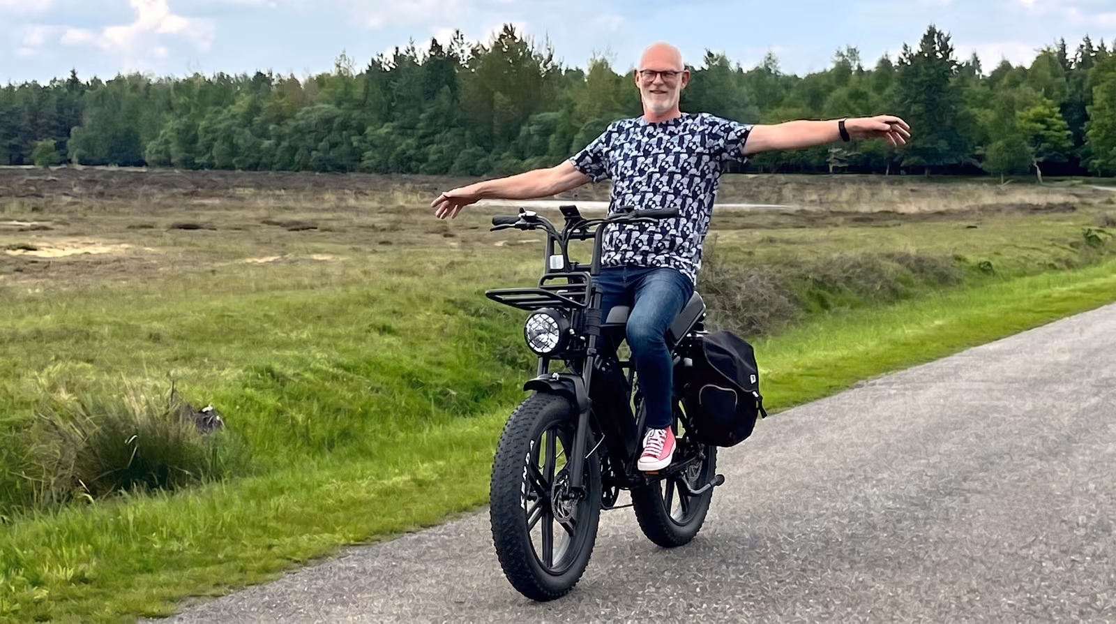 E-biker rijdt ontspannen met gespreide armen over een bospad, een tevreden koper die de juiste match vond