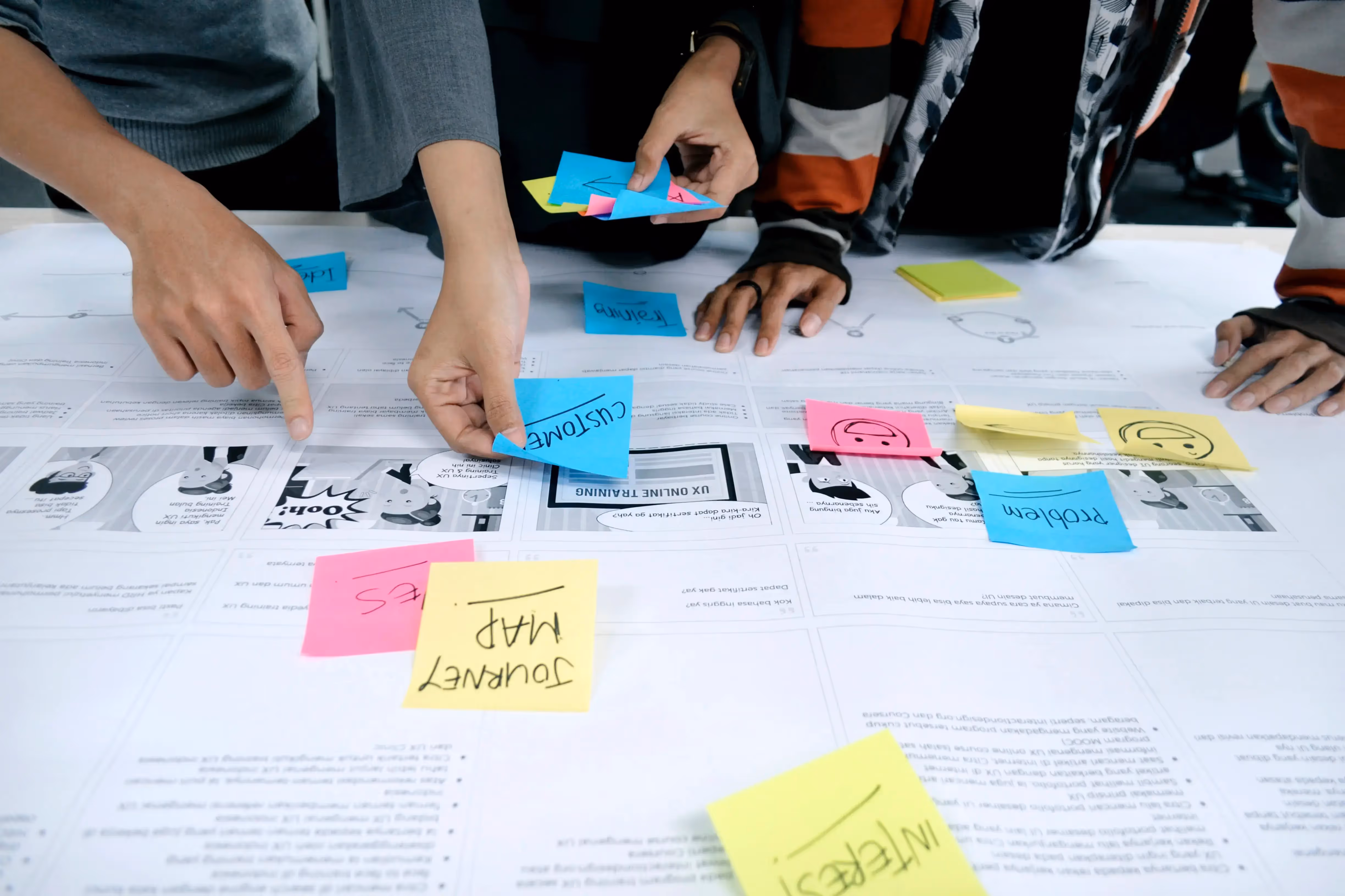Many hands placing sticky notes on a white board - UserVoice Images