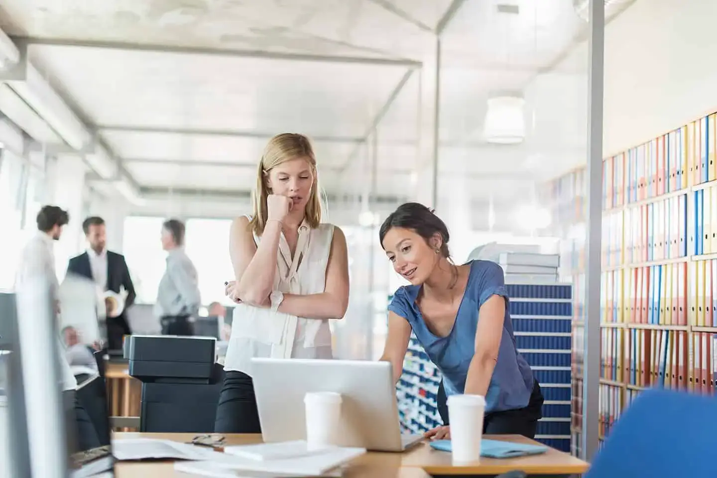 Two women working on a laptop in an office. - UserVoice Images