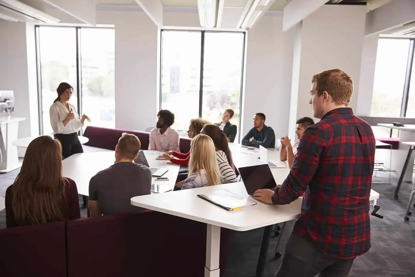A group of people sitting around a table with laptops. - UserVoice Images