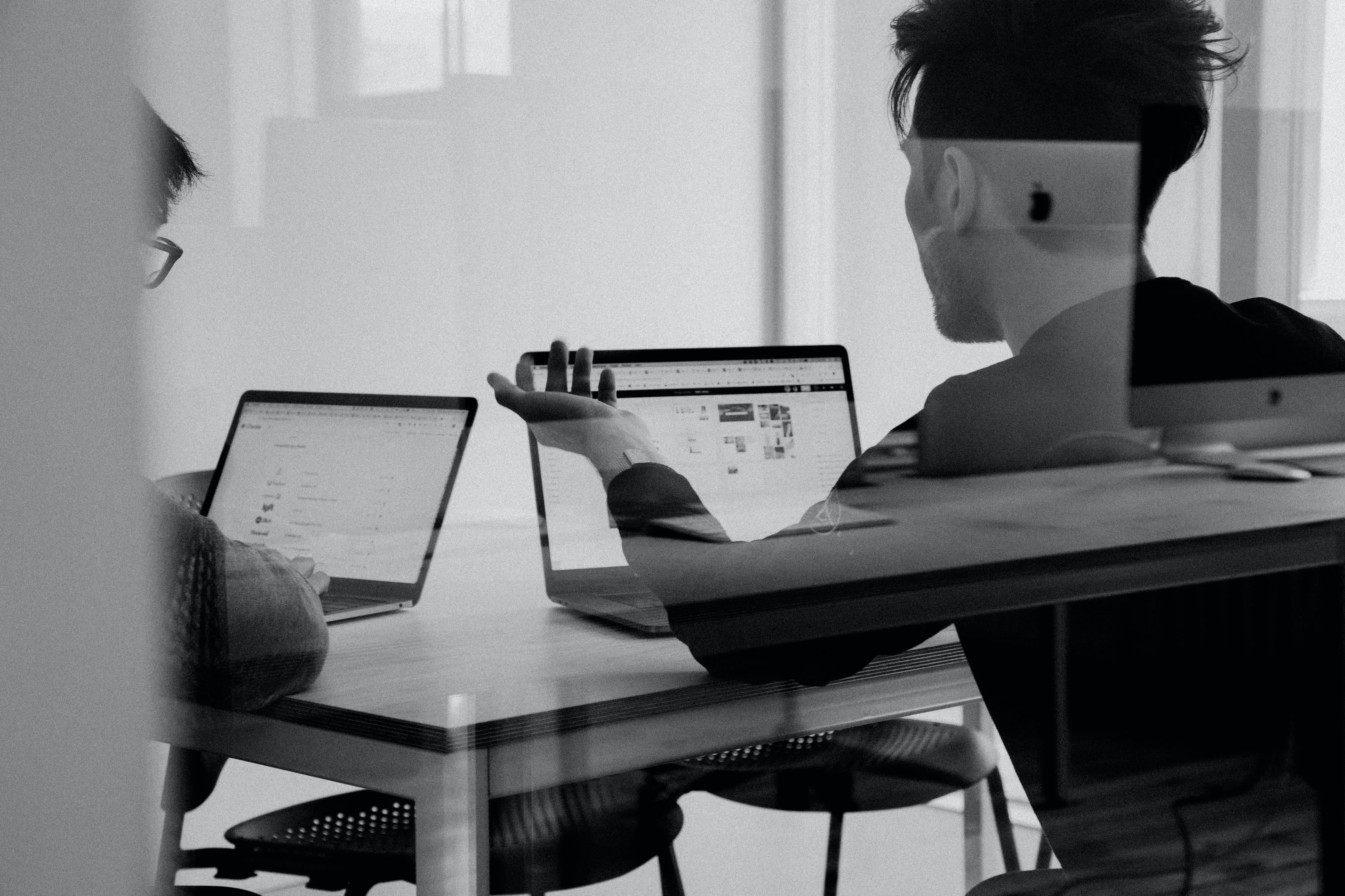 A man sitting at a table with a laptop. - UserVoice Images