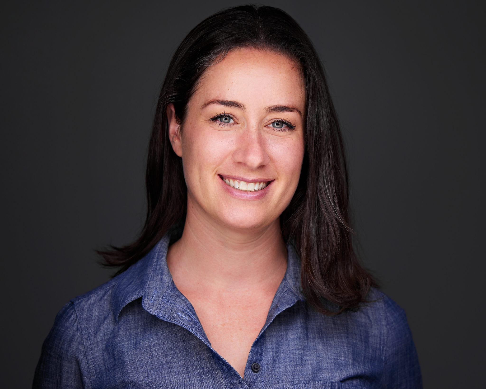 A woman wearing a blue shirt and smiling. - UserVoice Images