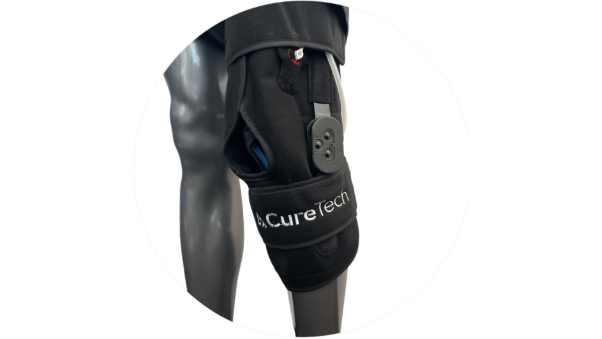 Black knee brace with CureTech logo and electronic components on a mannequin leg.