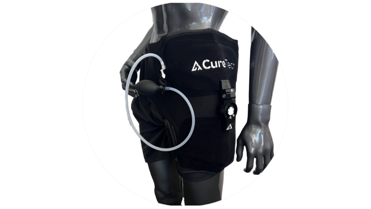 Black mannequin wearing a black CureTech hip device with adjustable straps and a connected hand pump.