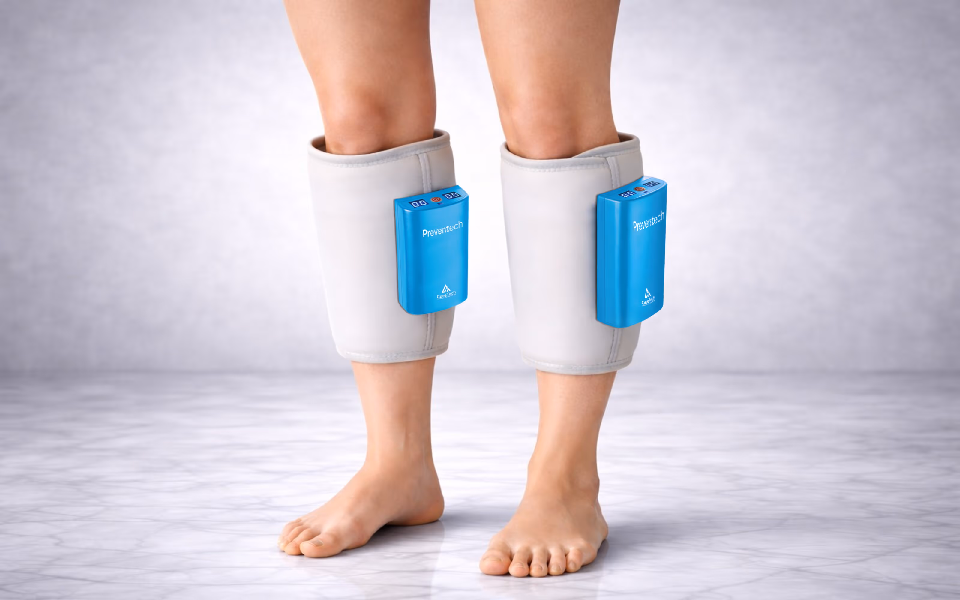 Bare legs wearing white calf sleeves with blue Preventech devices attached on the front.