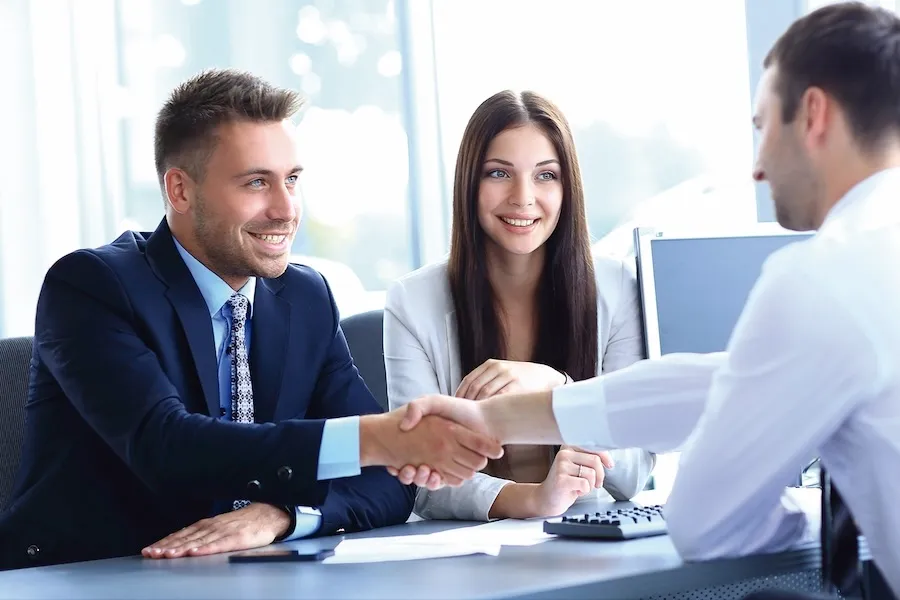 An executive shaking hands with H.O. personnel.