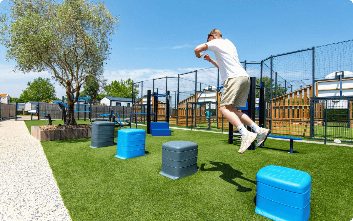 Before and after images of an outdoor grassy area in Lizy-sur-Ourcq, showing a plain lawn before and a 3D integration of a fitness park with exercise equipment added on a paved section.