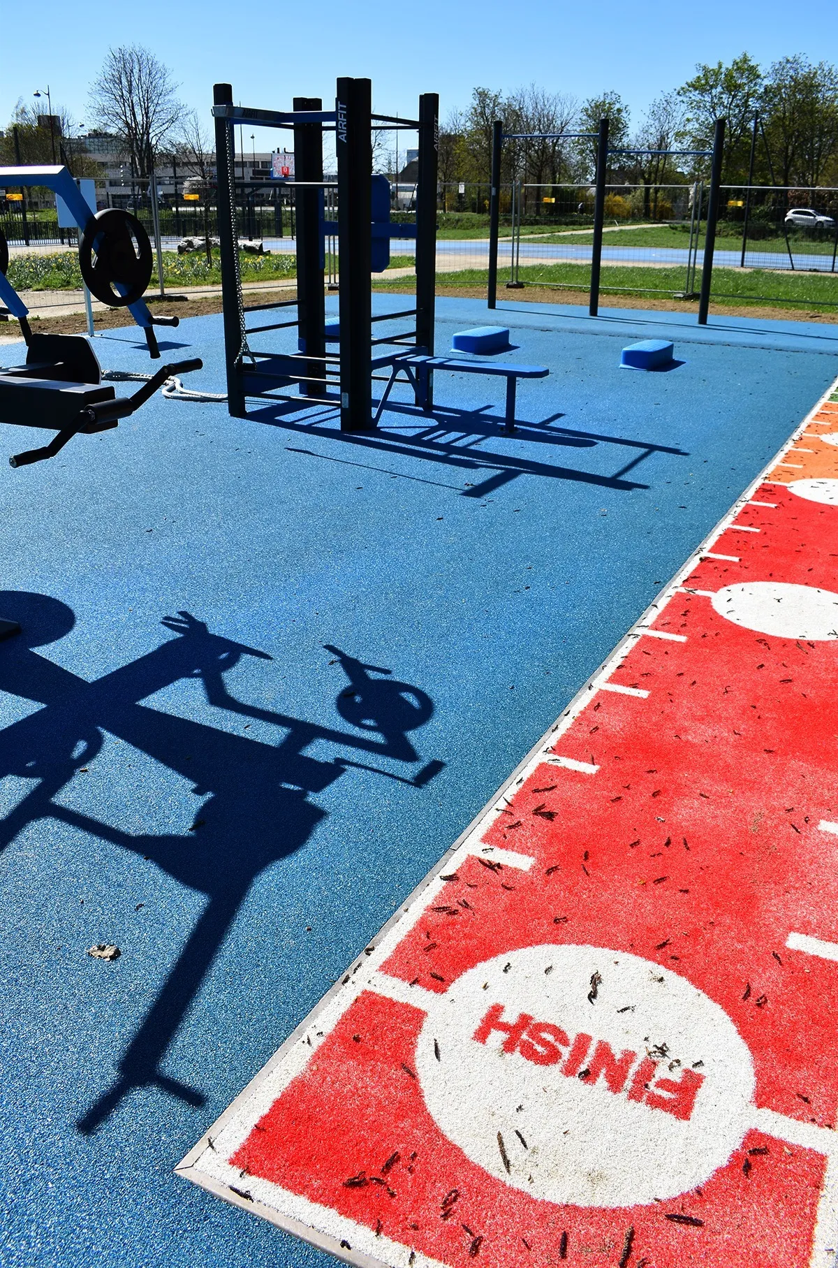 Aire de fitness extérieure AirFit avec sol sportif bleu et piste rouge