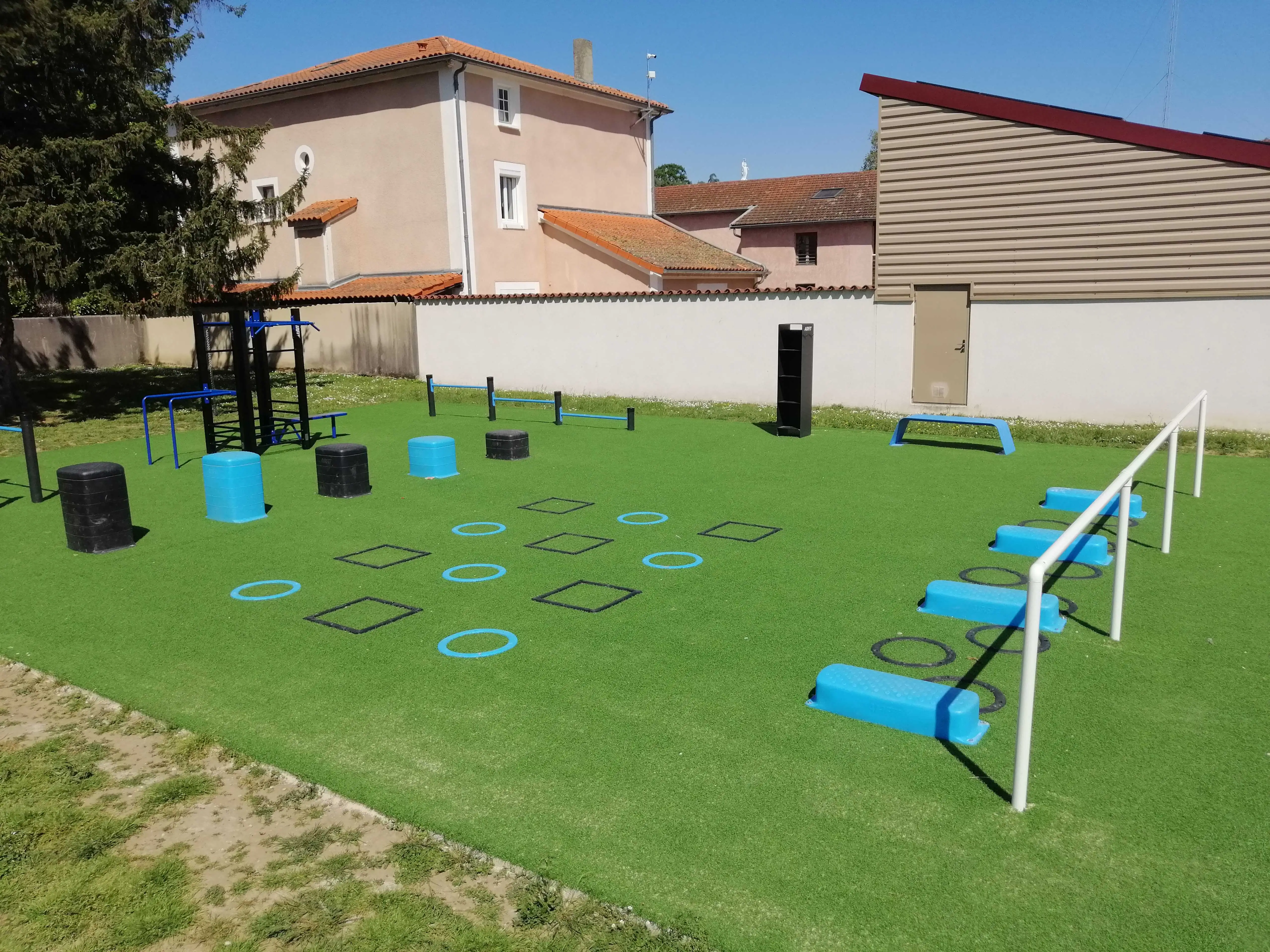 Parcours sportif extérieur avec plots, marquages au sol et barres d’entraînement à Toussieu