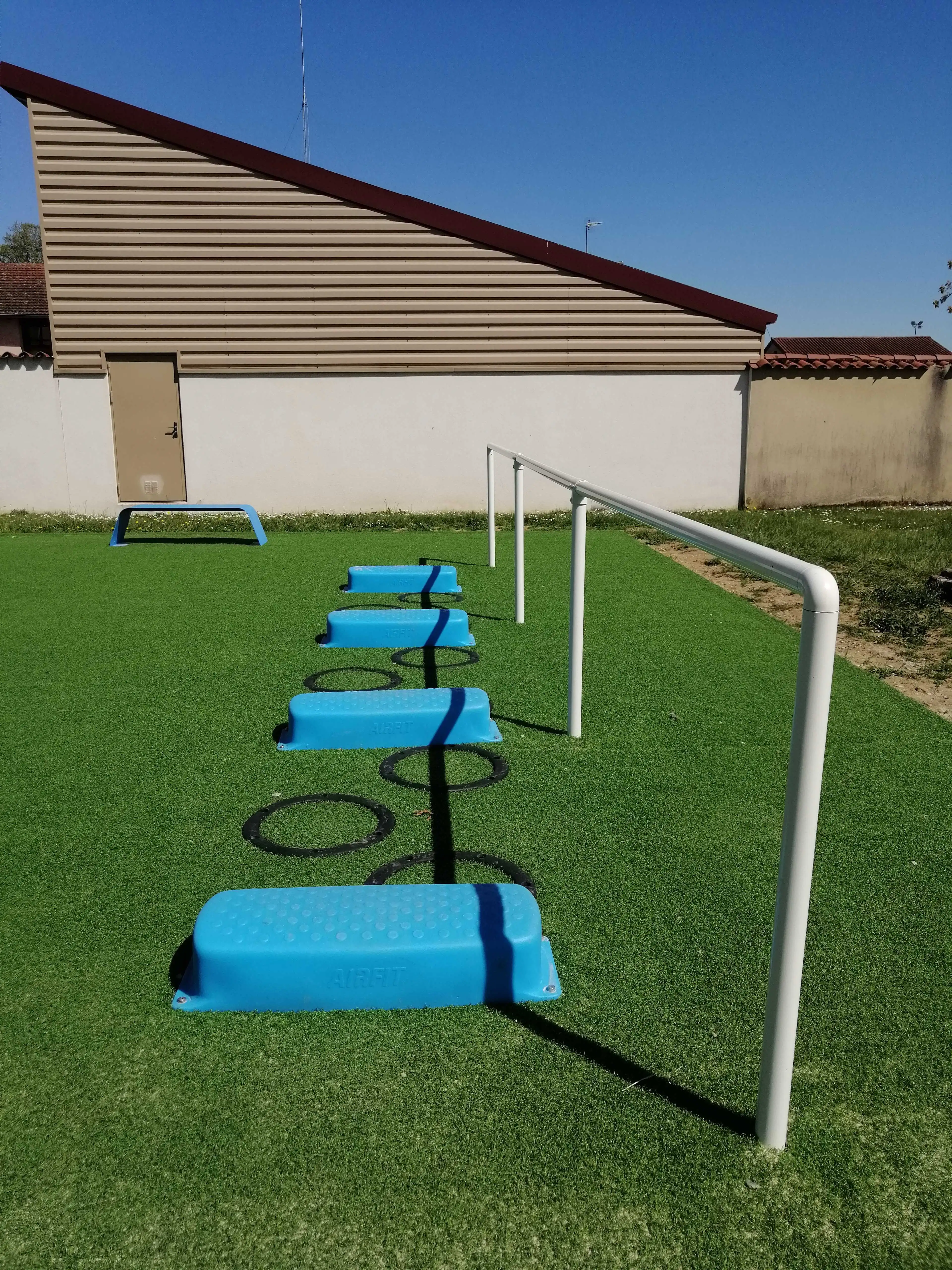 Zone d’entraînement extérieure avec marches bleues et rampe d’équilibre AirFit