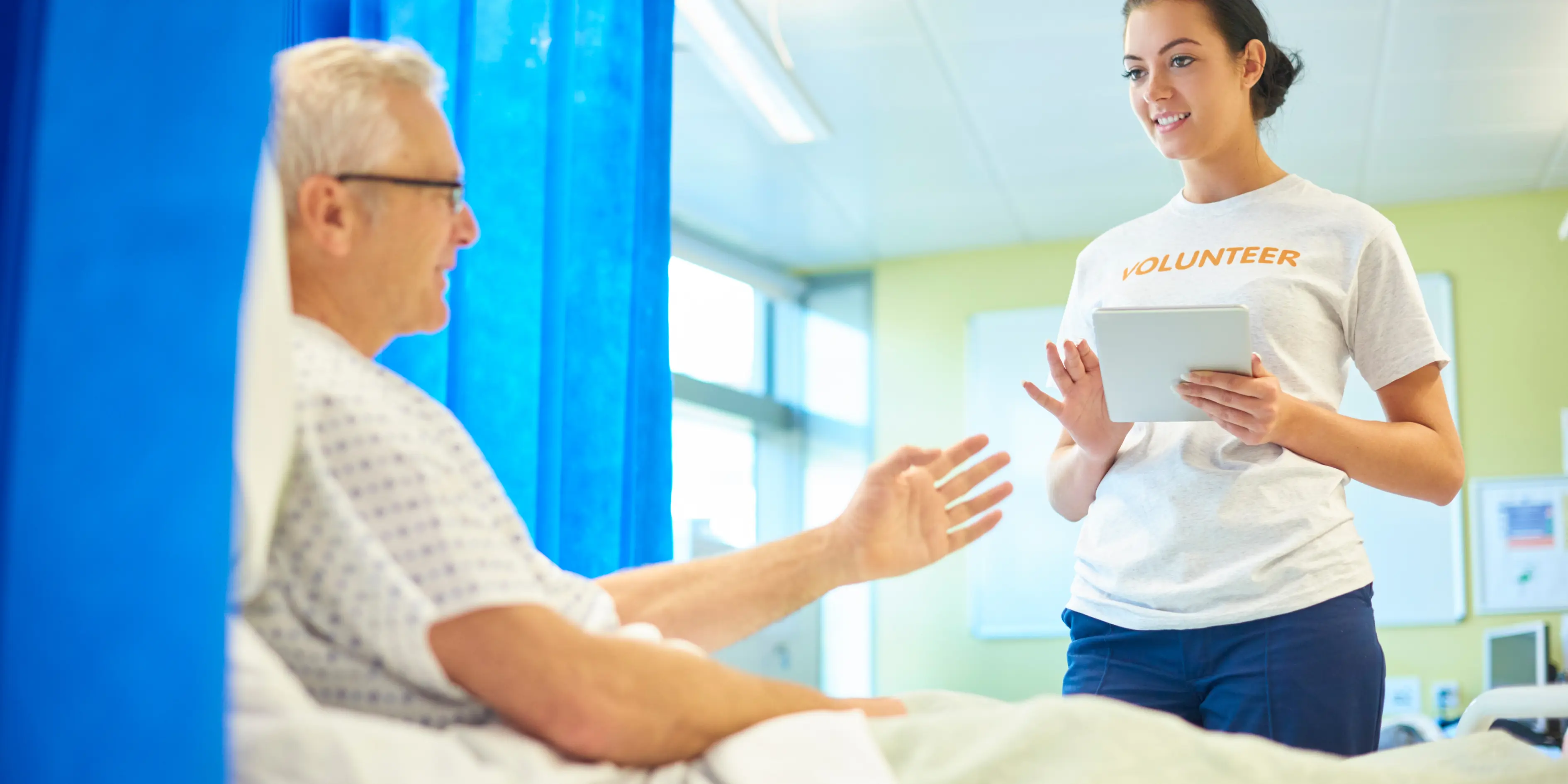 Volunteer talking with a hospital patient in London volunteering London hospitals and care homes.,