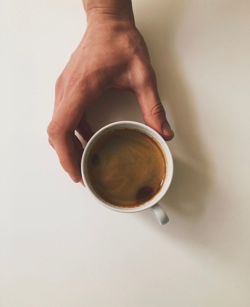 Hand holding cup of black coffee