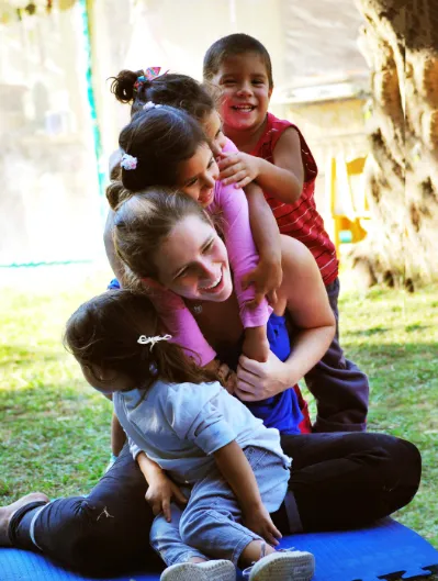 A helper  having fun  with young children in Argentina.