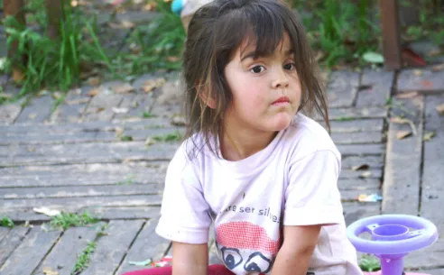 A young girl day dreams during playtime.