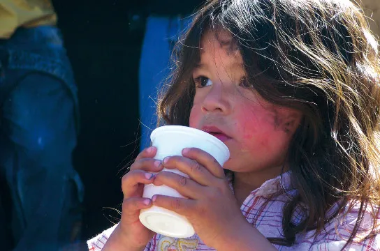 A cute girl embraces her drink.