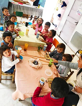 LEP kids eating and drinking at a classroom table.