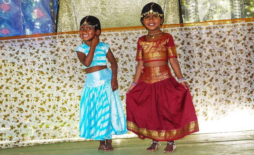 Two girls in brightly colored dancing costumes.