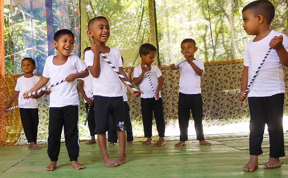 A group of pre school boys laugh with one another.