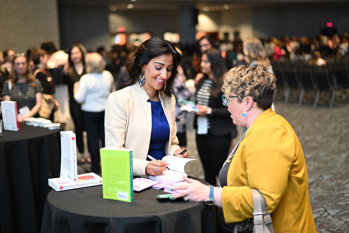 Dr. Shimi Kang signing books for readers at an event
