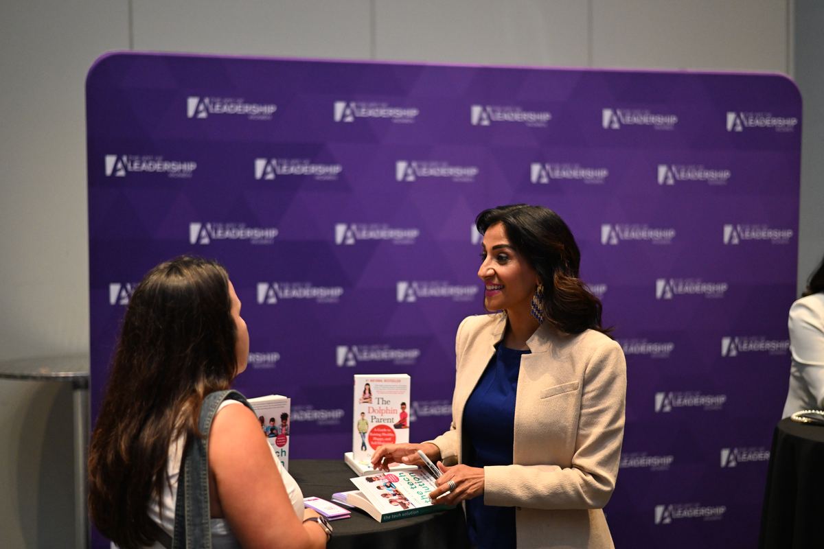Dr. Shimi Kang talking with attendees at a leadership summit