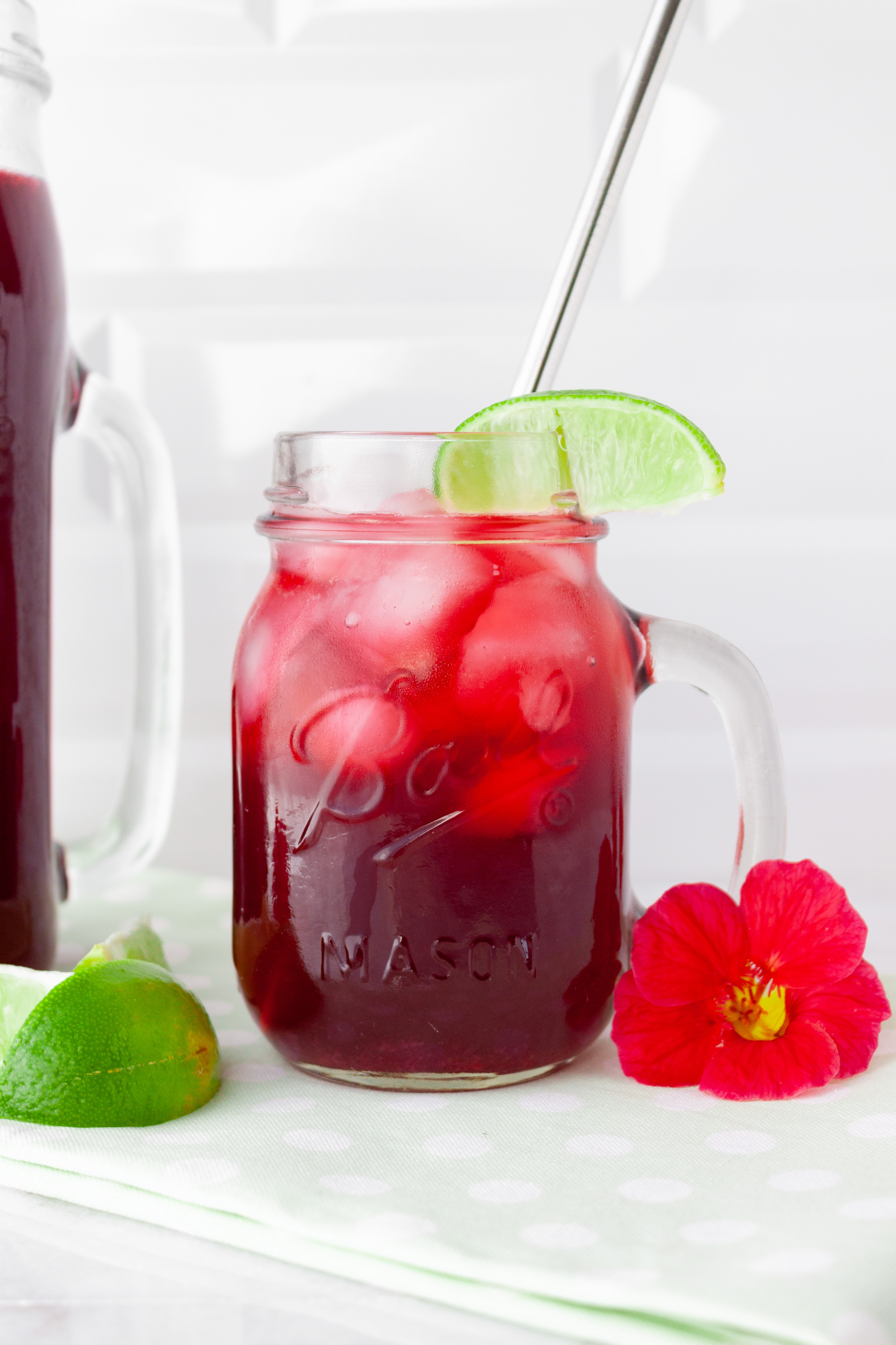 Hibiscus Limeade served in a glass over ice and garnished with a lime wedge
