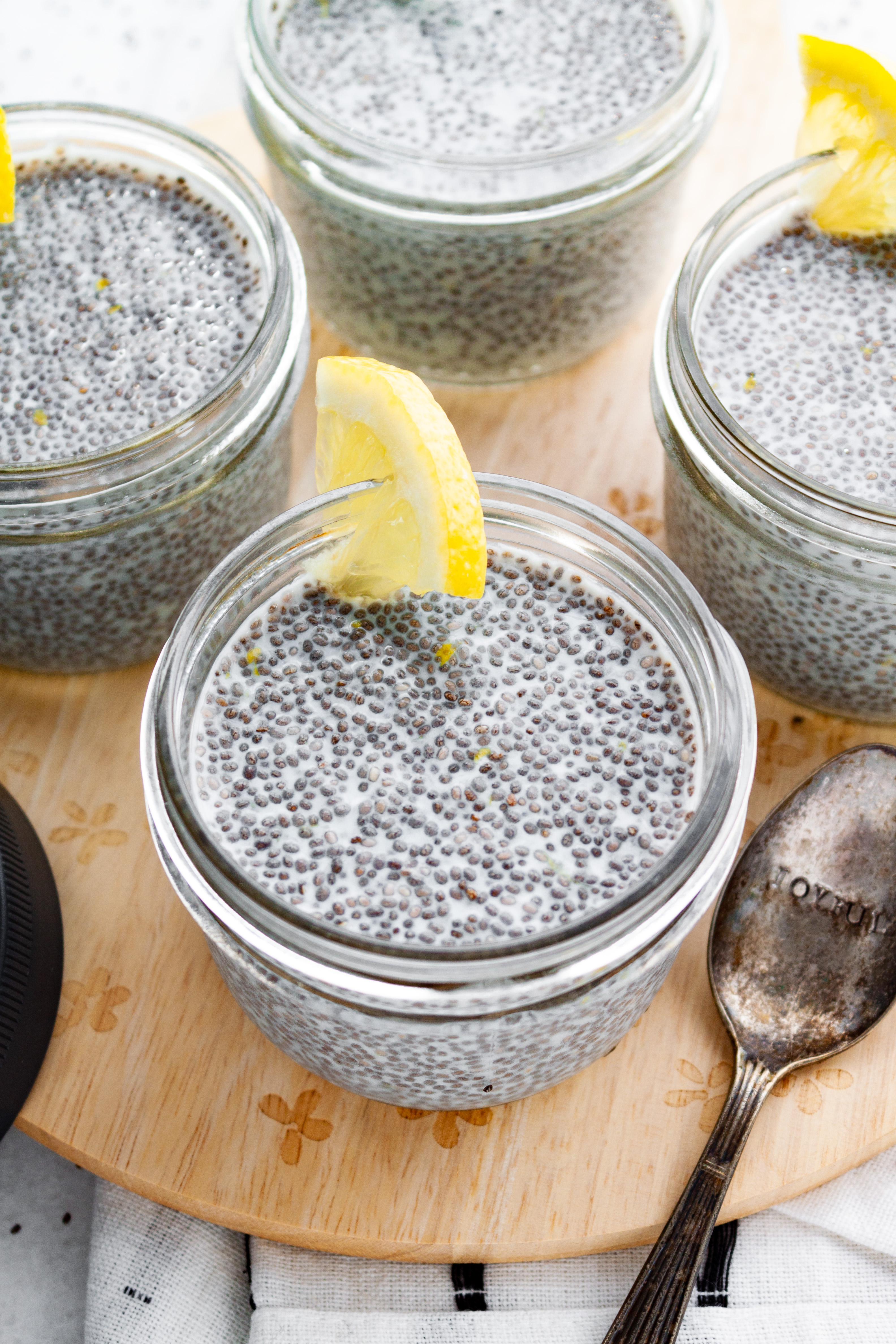 Four jars of finished Lemon Chia Pudding garnished with lemon slices