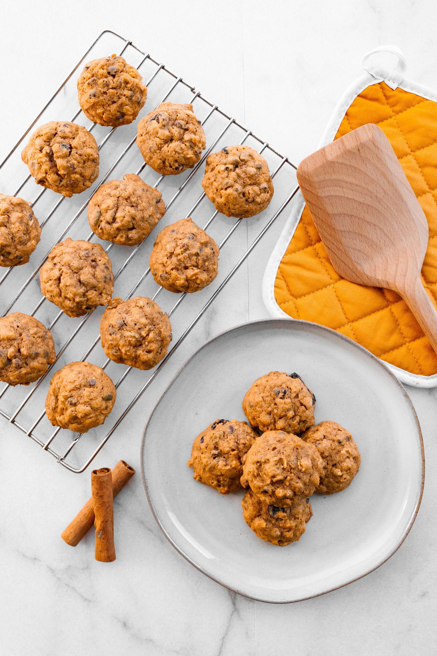 Finished cookies on a wire rack to cool, plus five cookies stacked on a plate  to serve