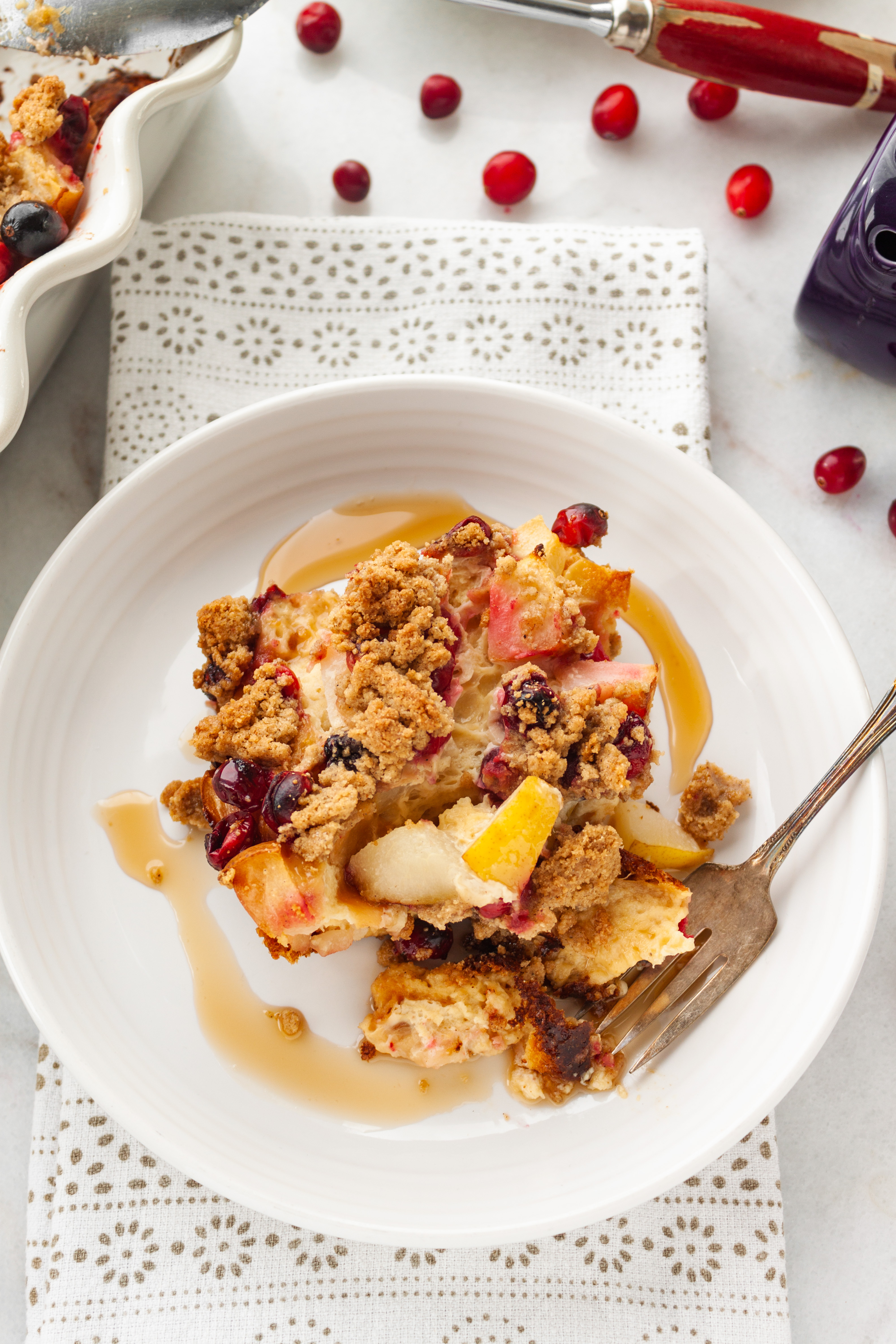 Cranberry Pear Baked French toast served on a plate drizzled with maple syrup 