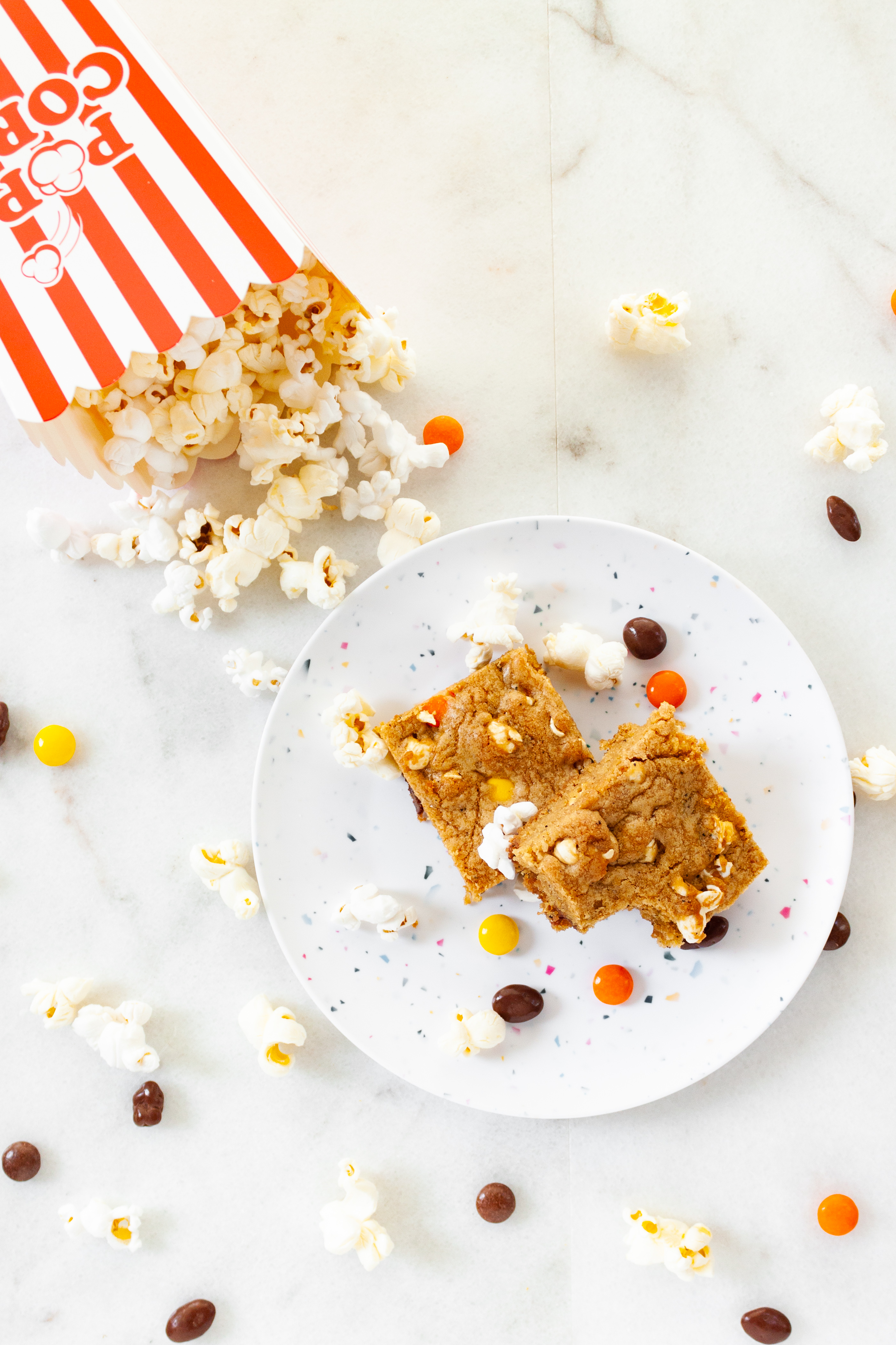 Two Movie Night Cookie Bars on a plate with a side of popcorn