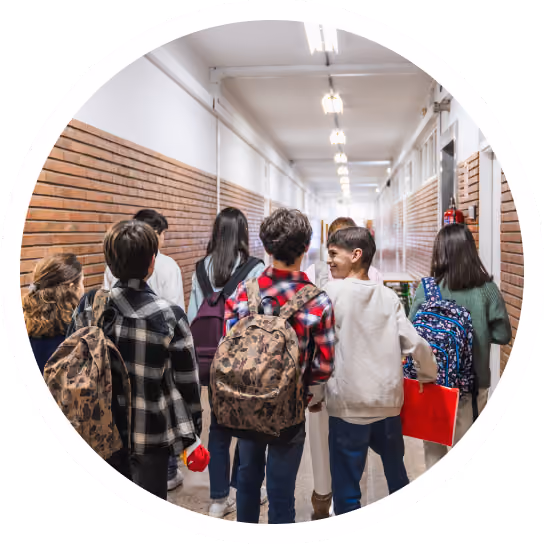 Students walking together down a school corridor, seen from behind.