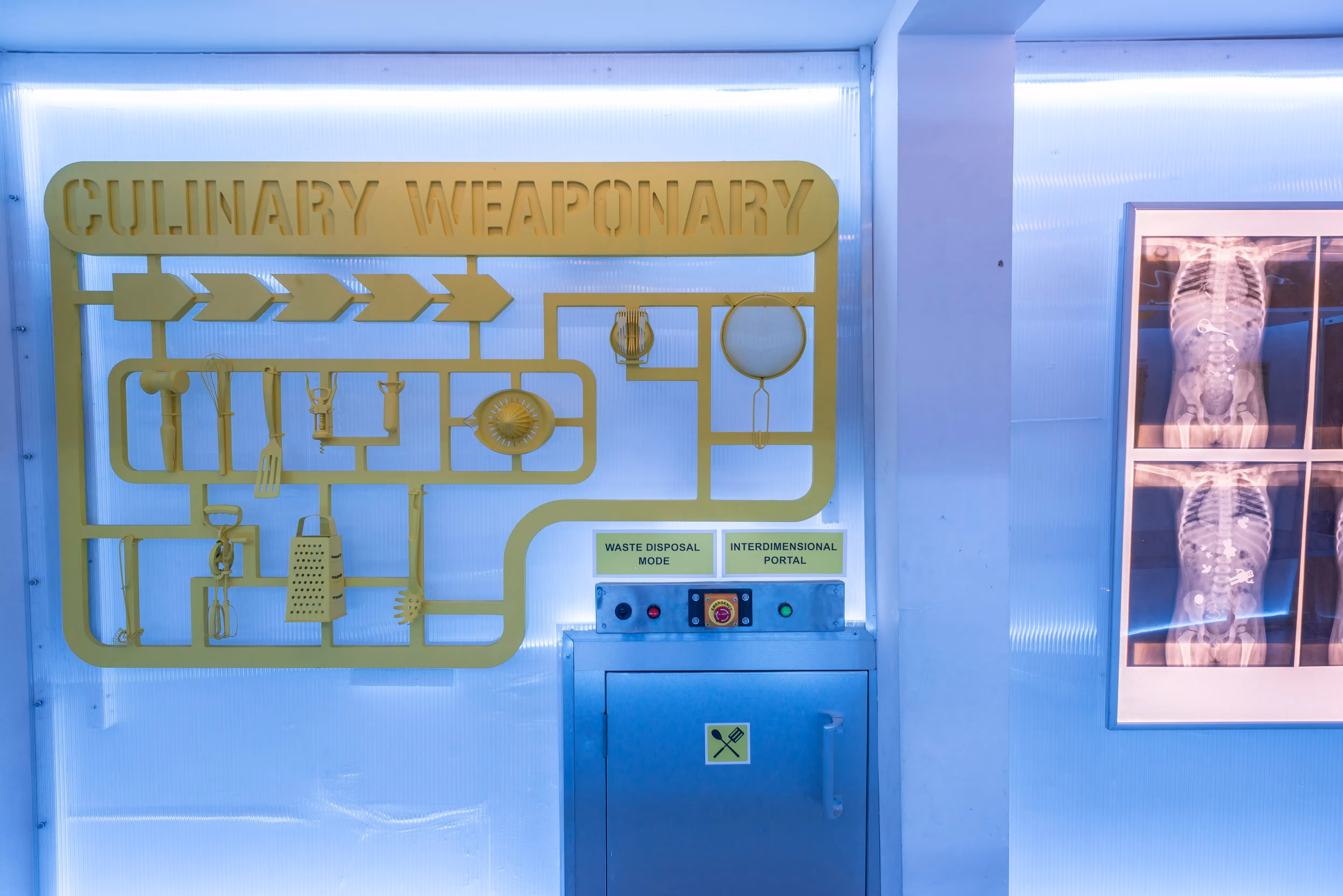 Inside a laboratory with a "culinary weaponry" sign and images of x-rays with kitchen untensils showing up in people's ribcages as part of an immersive dining event.