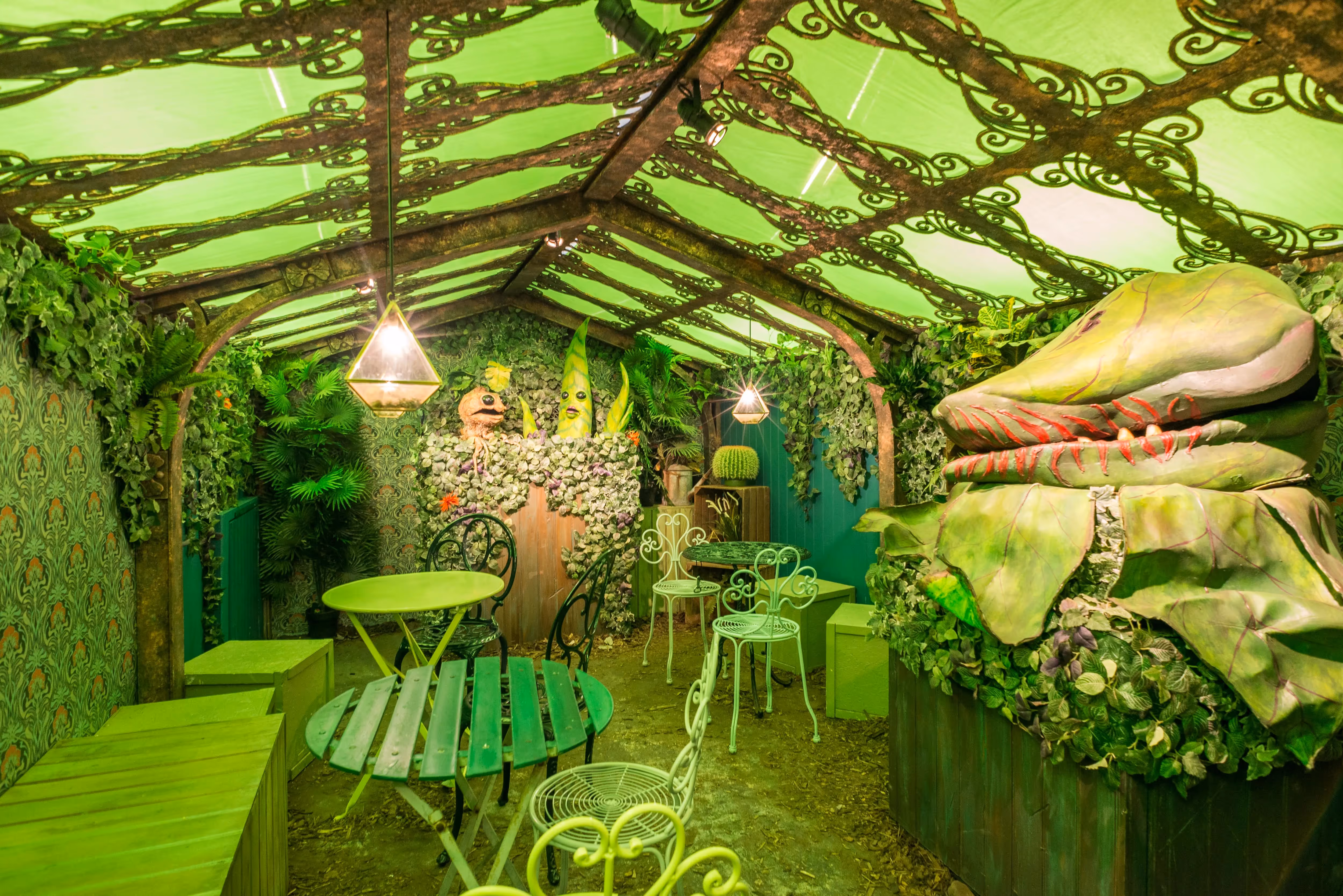 An immersive dining experience, a room fabricated to look like outside with oversized plants and vegetation as part of the Chamber of Flavours.