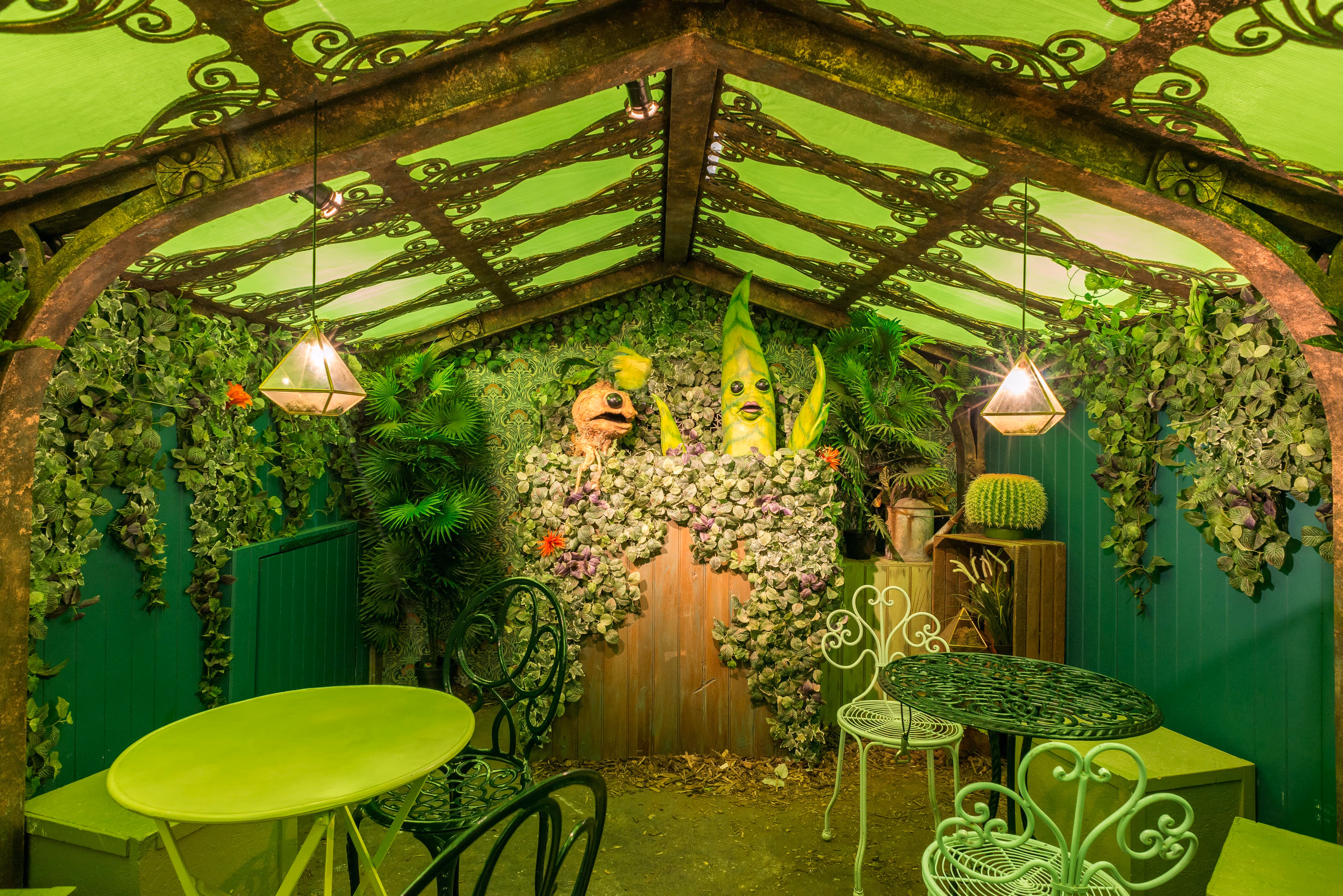 A dining room set that been fabricated to look like its outside with plants and vegetation as part of the Chamber of Flavours immersive dining experience.