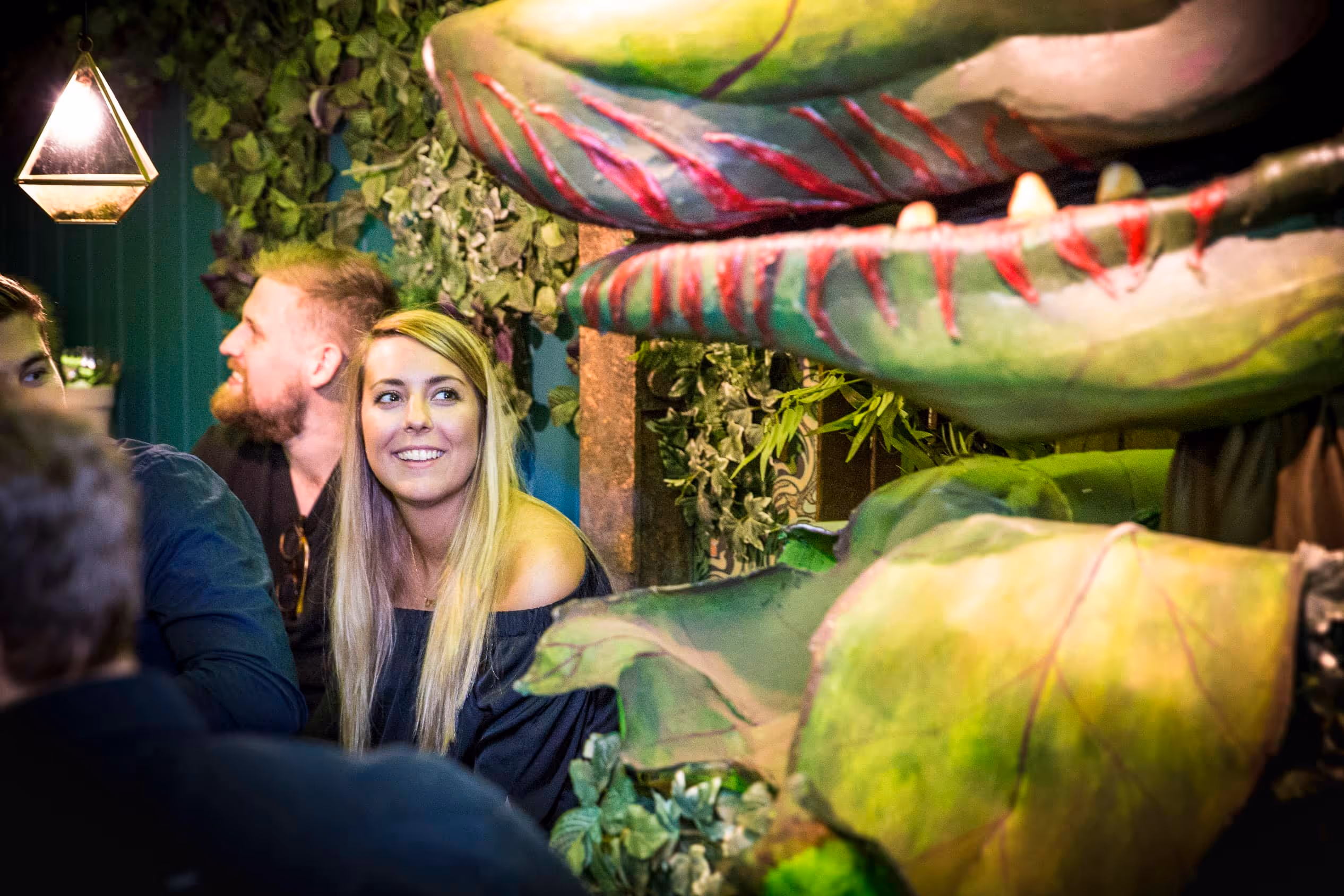 Diners eat at the outdoor dining set, with large automated plants at an immersive dining event in Hoxton.