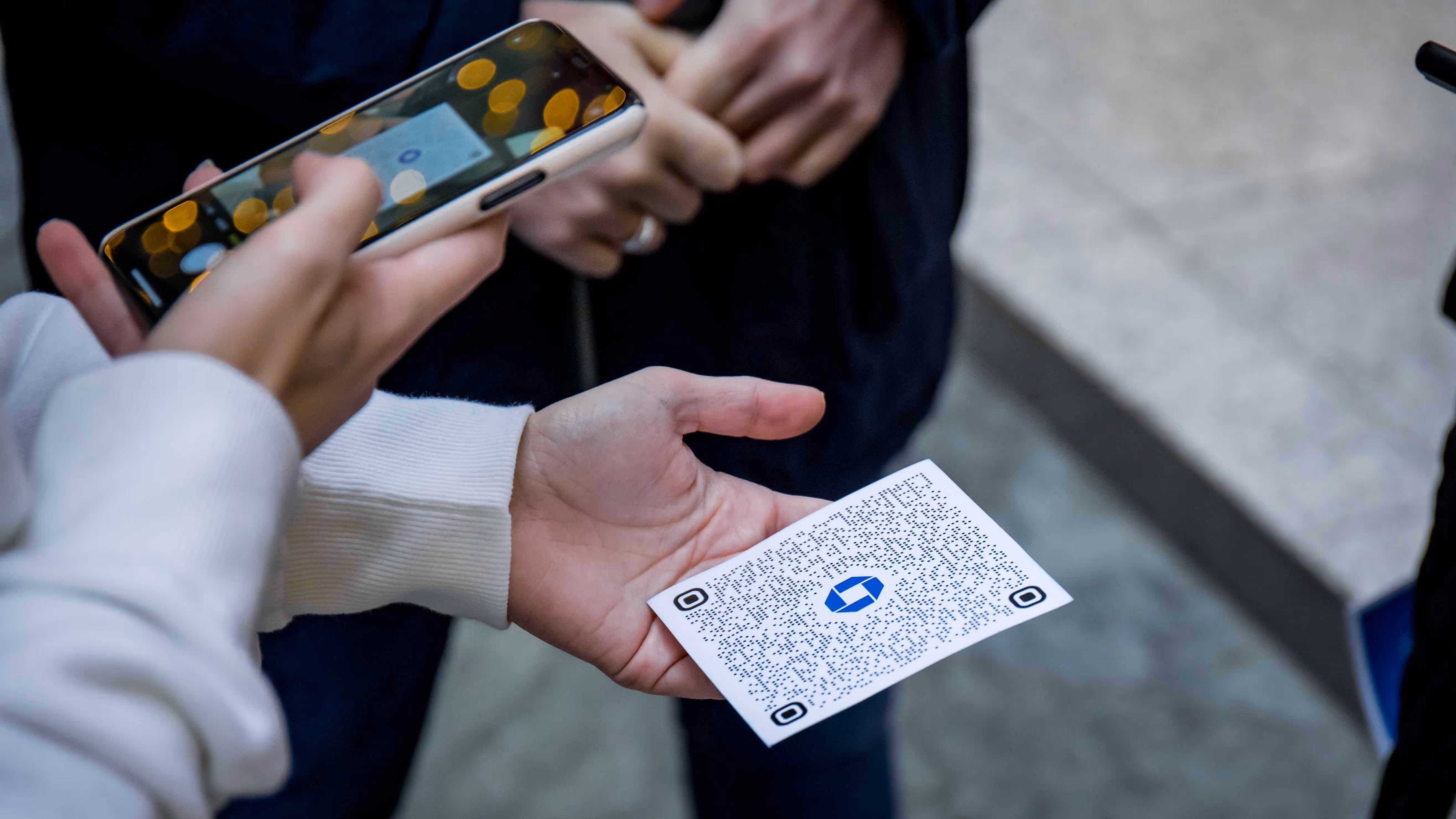 Mobile phone users reading a printed QR code at the Chase bank experiential event.
