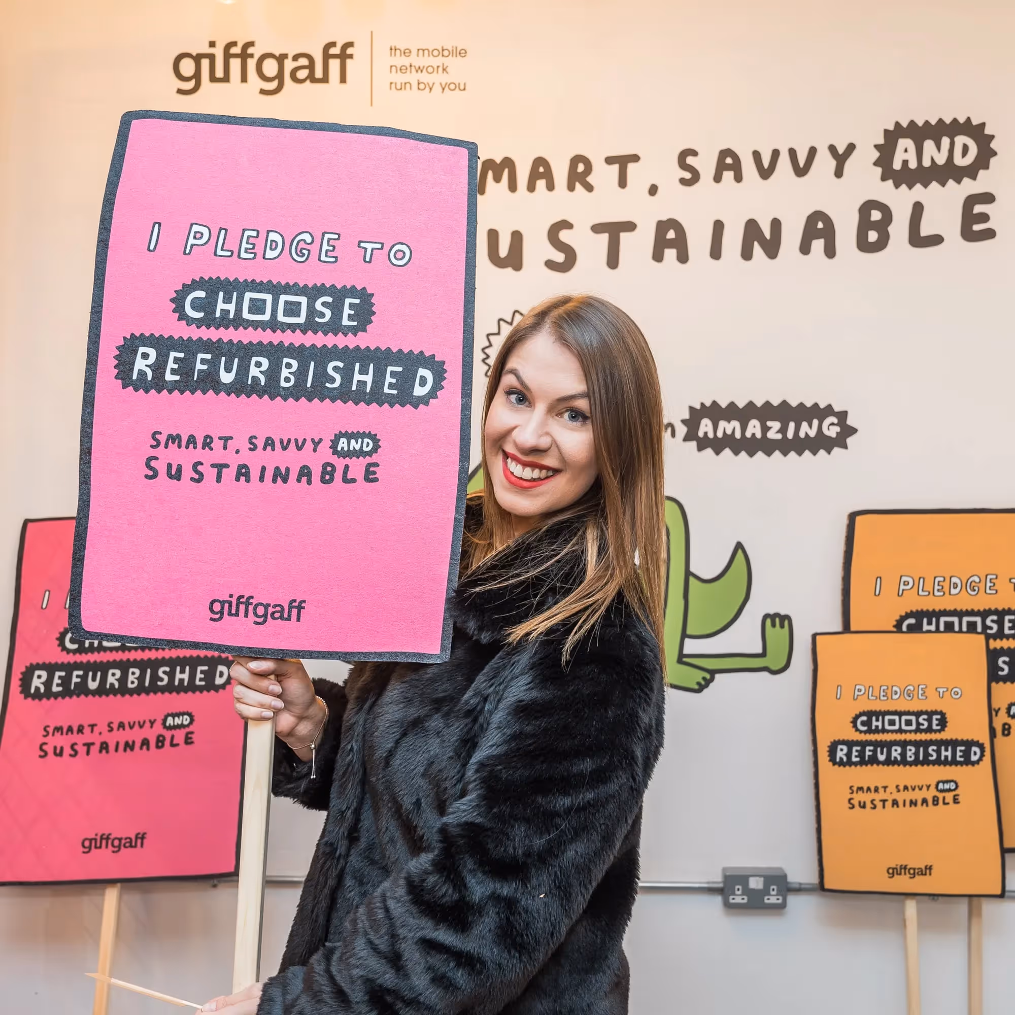 A customer holds a sustainability pledge placard in the giffgaff pop-up shop.