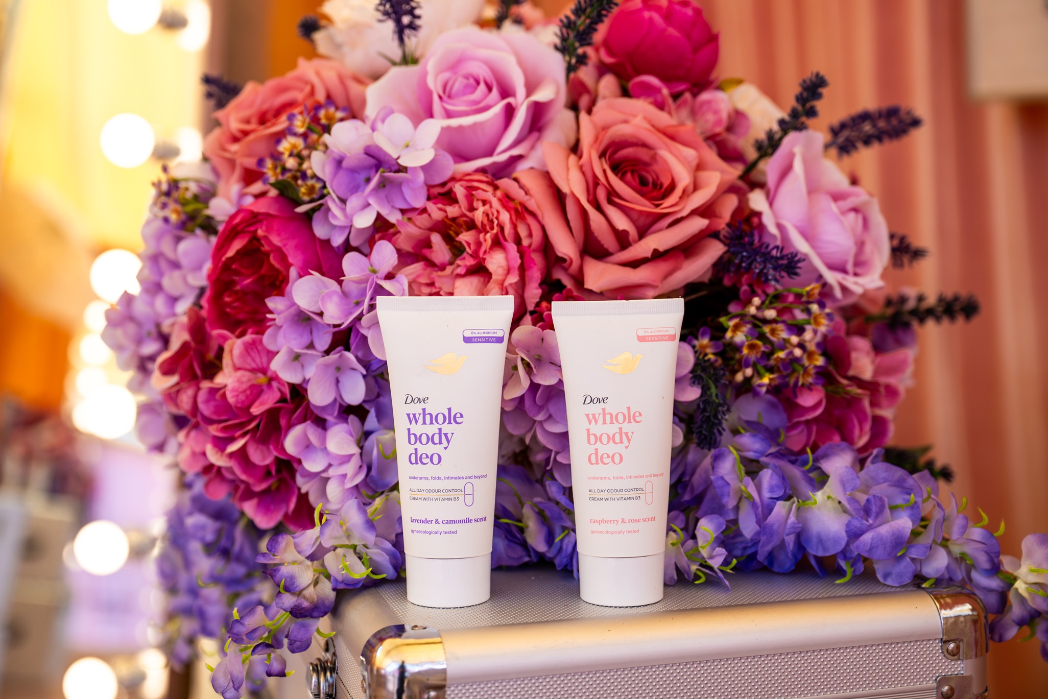 Dove Whole Body range in front of pink and purple florals at 'Backstage with Dove' beauty activation by Bearded Kitten