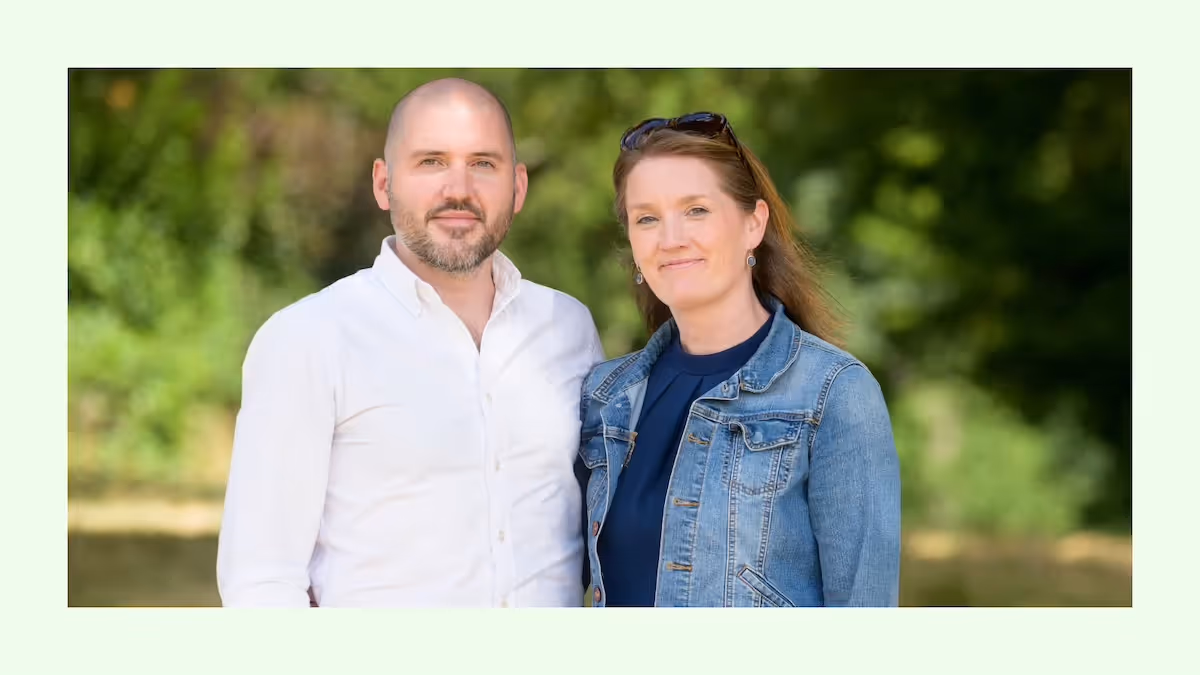 Man and woman stood side by side looking at the camera.