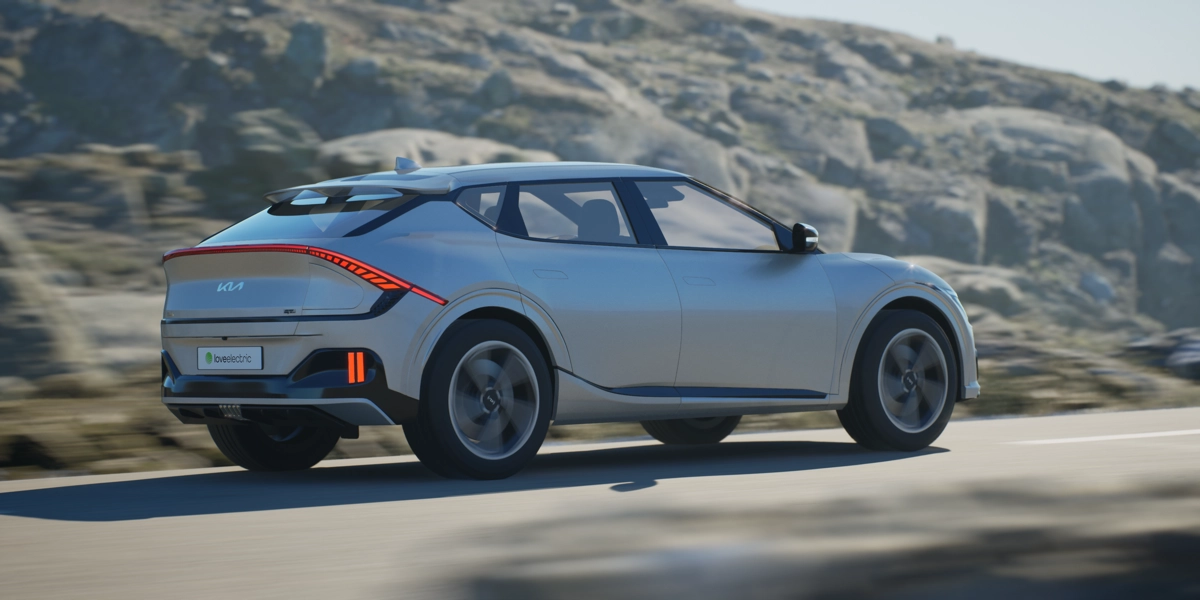 A grey Kia EV6 drives through a mountain road