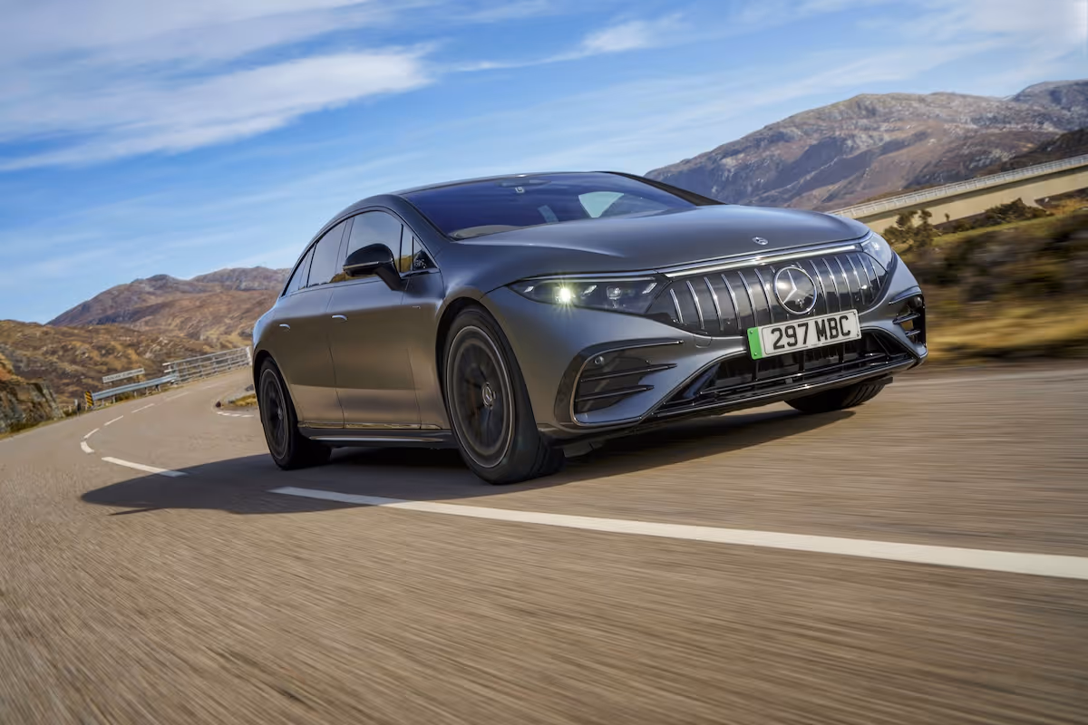 Mercedes EQS in black driving down on a road at speed