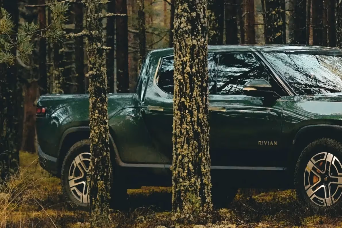 Electric pickup truck parked in a forest
