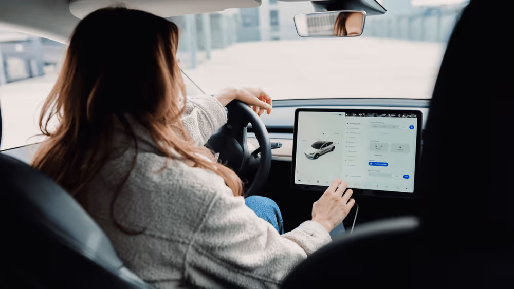 Woman adjusting setting on a screen in an electric car