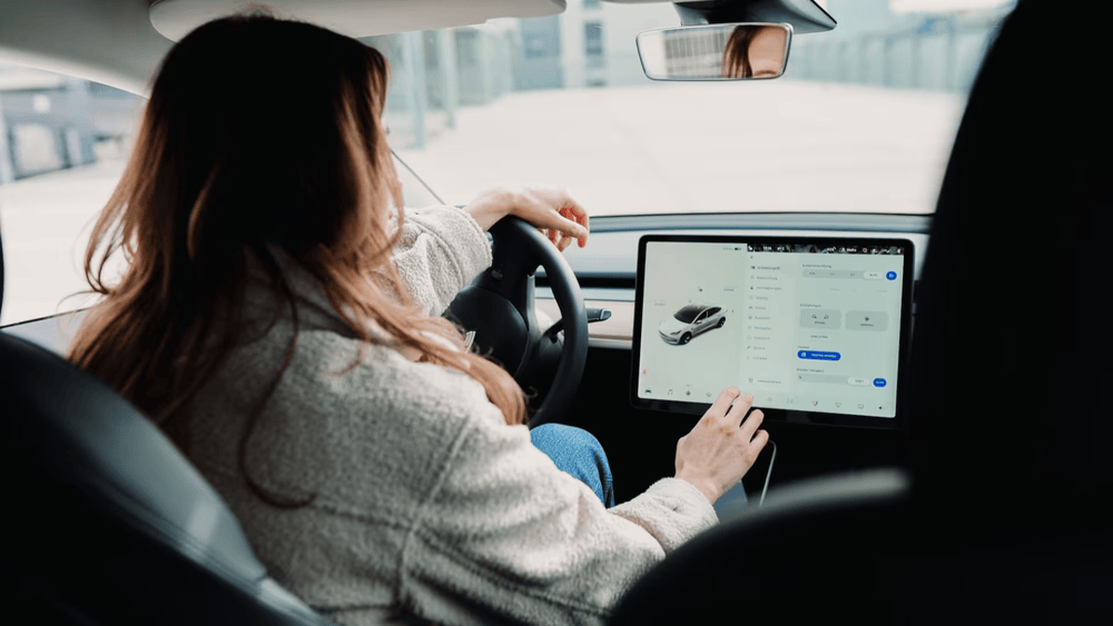 Woman adjusting setting on a screen in an electric car