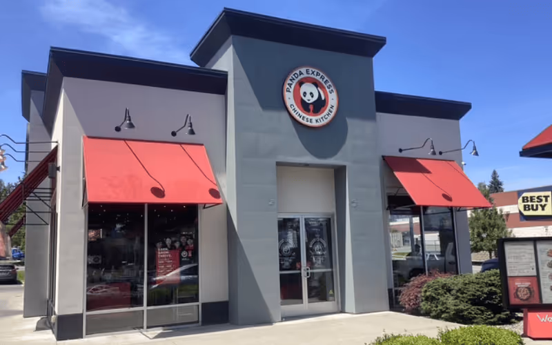 Panda Express restaurant building with red awnings and a circular sign on a sunny day.
