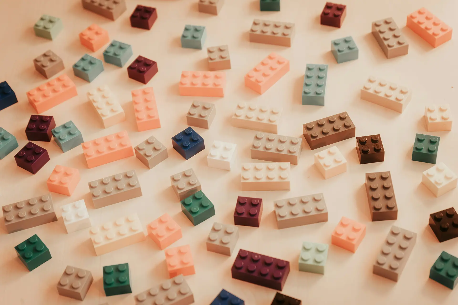 Various colored plastic building blocks scattered randomly on a flat, light surface.