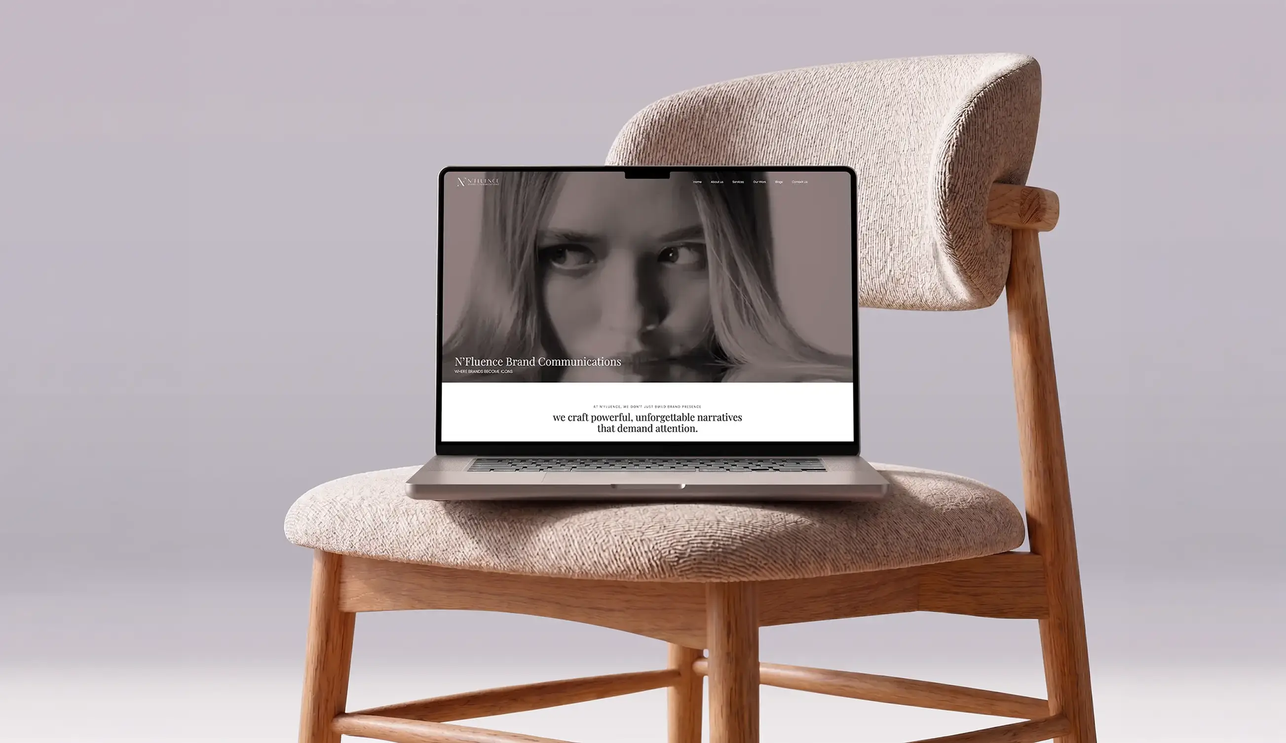 A laptop displaying a website with a close-up black and white image of a woman's face and text about crafting powerful, unforgettable brand narratives, placed on a beige cushioned wooden chair with a curved backrest.