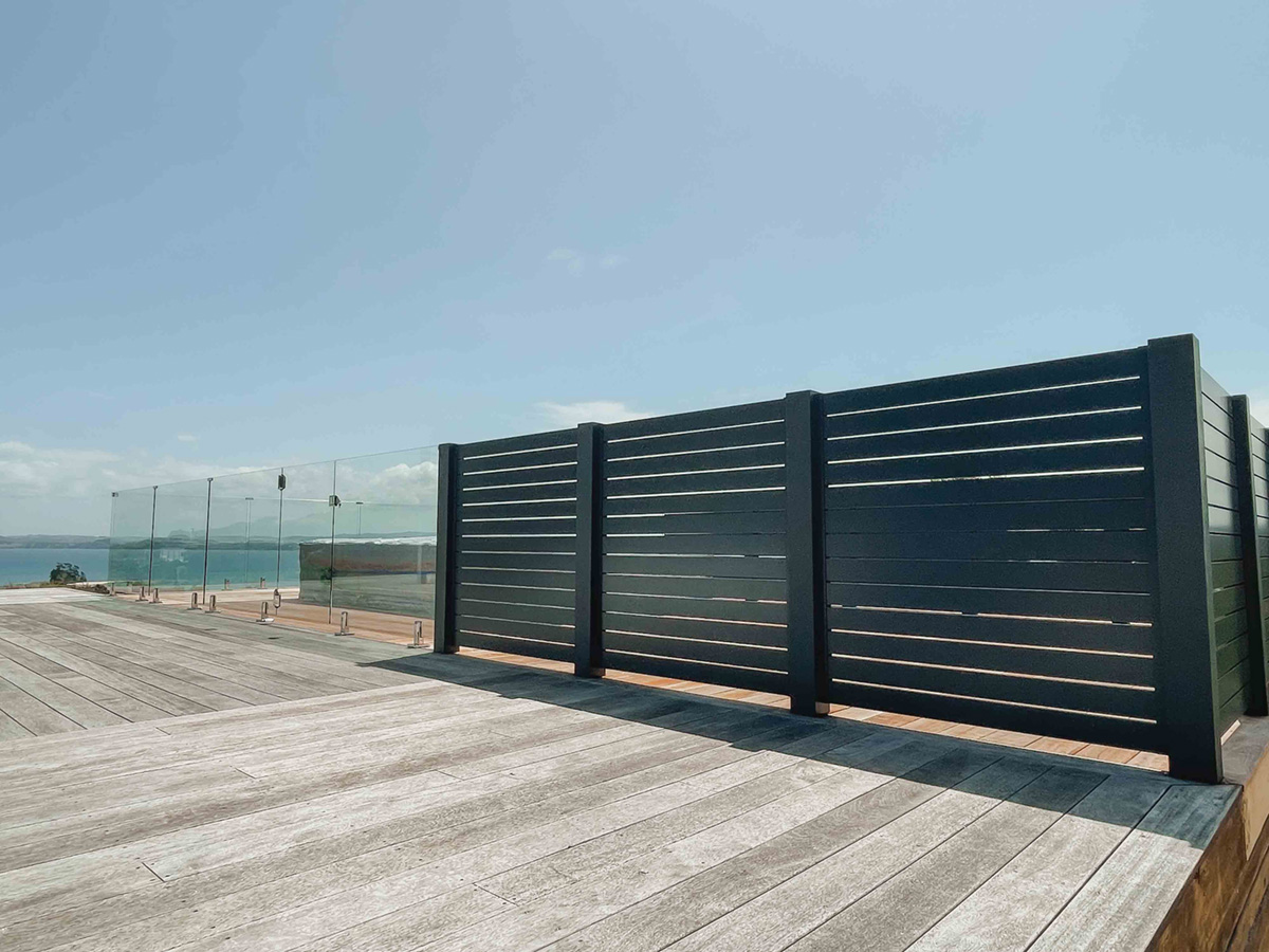 Dark slat privacy screen on a coastal deck