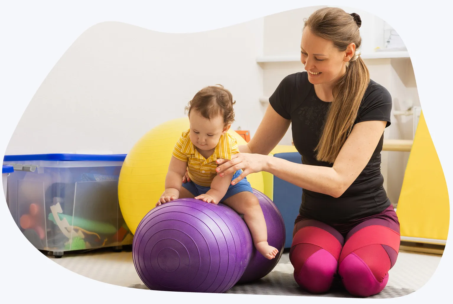 Pediatric occupational therapist working with child on inflatable ball
